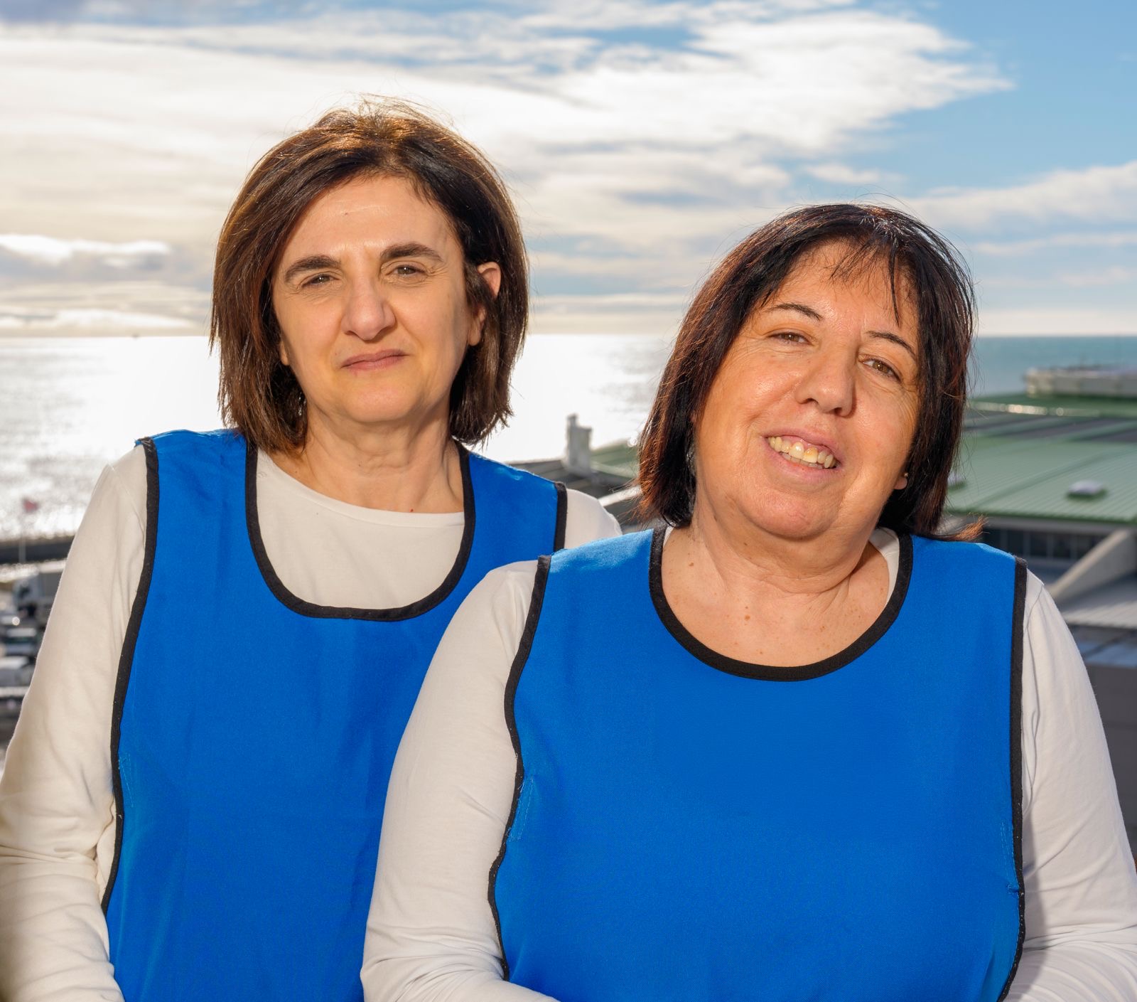 Due addette ai servizi della Residenza Archè, con il mare sullo sfondo